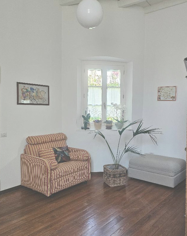 Sunlit minimalist living room with linen sofa and oak floors